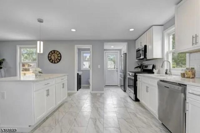39 Emma St, Plainfield City, NJ 07063 - kitchen with stainless steel appliances, a sink, light marble finish floors, white cabinetry, and a kitchen island