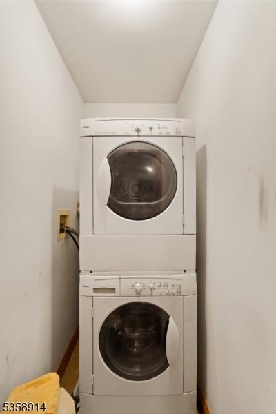 laundry room featuring estacked washer and dryer and baseboards