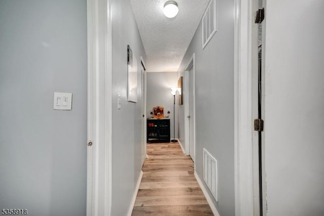 62 Taylor Dr, Franklin Twp, NJ 08823 - hall featuring a textured ceiling and light wood-style floors