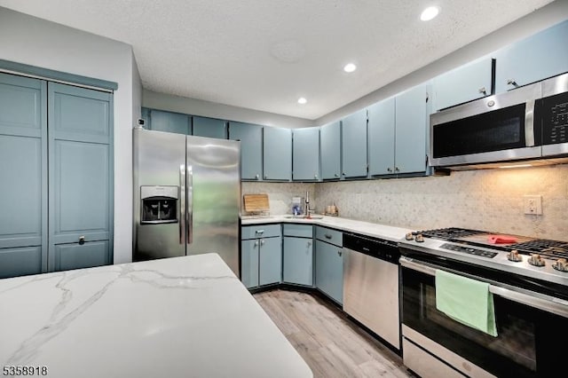 62 Taylor Dr, Franklin Twp, NJ 08823 - kitchen with stainless steel appliances, light wood-style floors, backsplash, light stone countertops, and recessed lighting