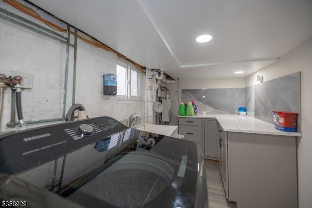 118 Holly St, Woodbridge Twp, NJ 07064 - laundry room with cabinet space, light wood finished floors, and water heater