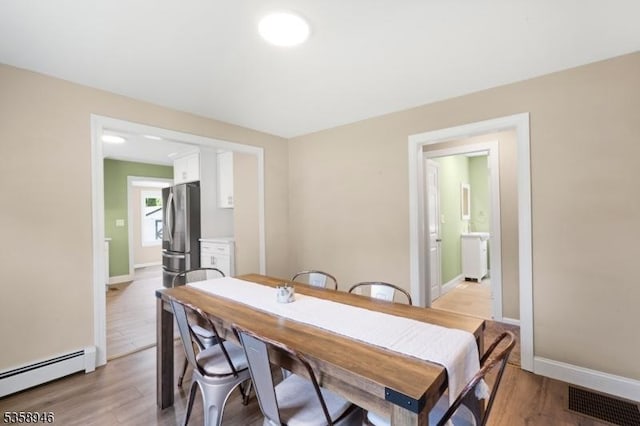 3 Raritan Ave, Roxbury Twp, NJ 07852 - dining area featuring a baseboard radiator, light wood-style flooring, and baseboards