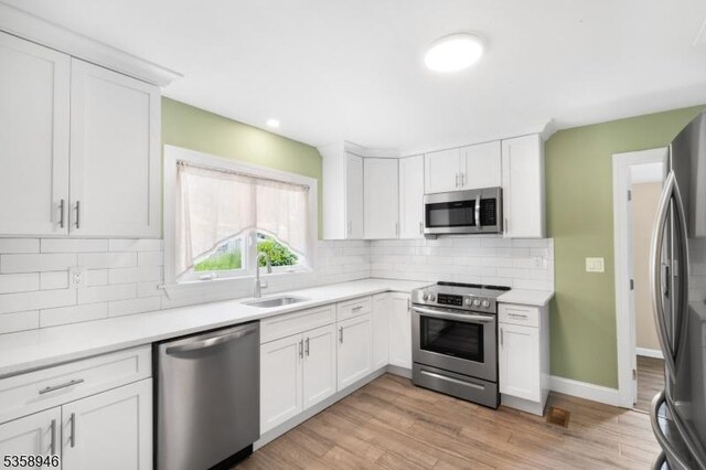 3 Raritan Ave, Roxbury Twp, NJ 07852 - kitchen with stainless steel appliances, a sink, light wood-type flooring, white cabinetry, and light countertops
