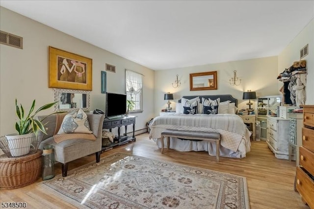 bedroom featuring light wood-style flooring and a baseboard heating unit