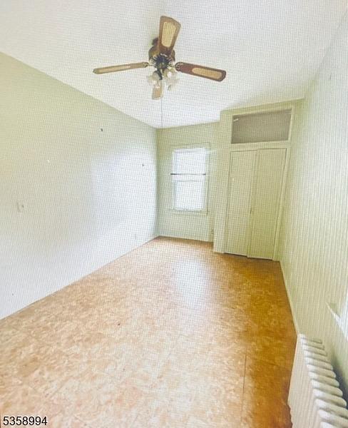 61 Thornall St, Carteret Boro, NJ 07008 - unfurnished bedroom featuring radiator heating unit and ceiling fan