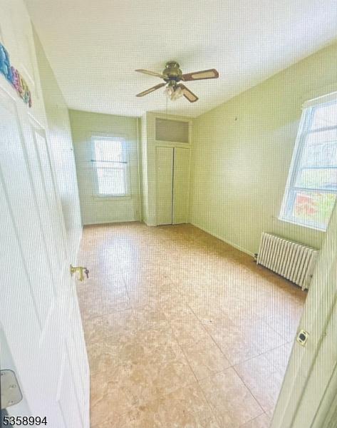 61 Thornall St, Carteret Boro, NJ 07008 - tiled spare room with radiator and ceiling fan
