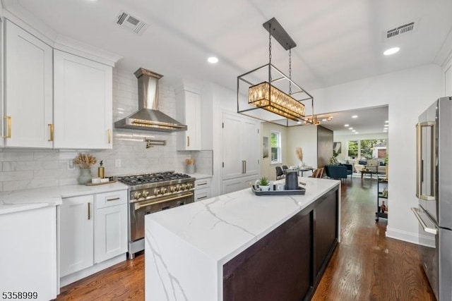 22 Race St, Nutley Twp, NJ 07110 - kitchen featuring wall chimney range hood, stainless steel appliances, a kitchen island, decorative backsplash, and white cabinets