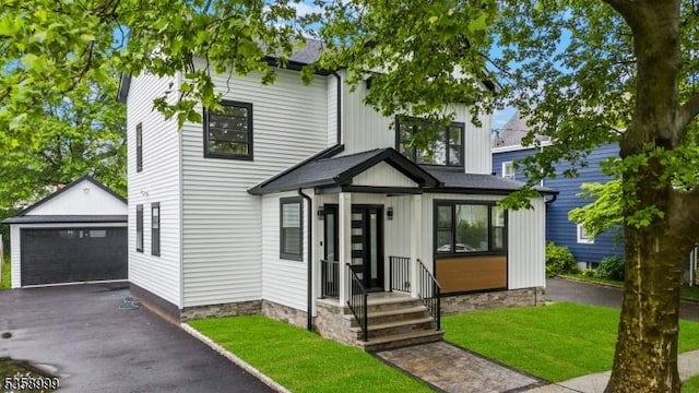 22 Race St, Nutley Twp, NJ 07110 - view of front of house featuring an outdoor structure, board and batten siding, a front yard, and a detached garage