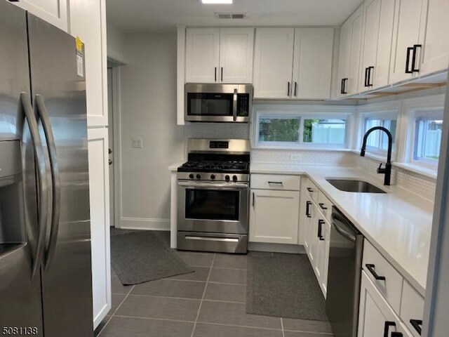 3 Janet Dr, Mine Hill Twp, NJ 07803 - kitchen featuring stainless steel appliances, a sink, dark tile patterned flooring, light countertops, and white cabinets