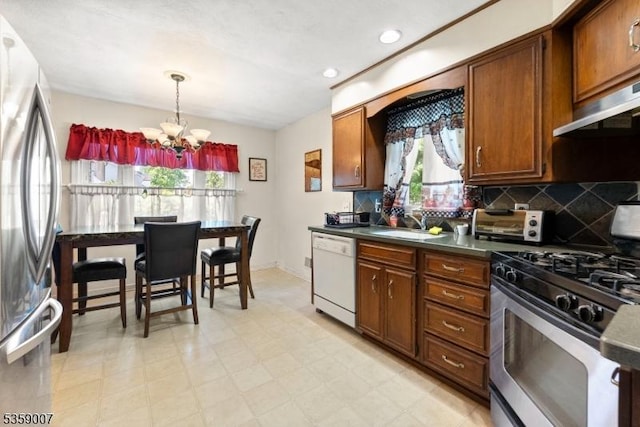 580 Mountainview Dr, North Plainfield Boro, NJ 07063 - kitchen featuring appliances with stainless steel finishes, a chandelier, backsplash, brown cabinetry, and dark countertops
