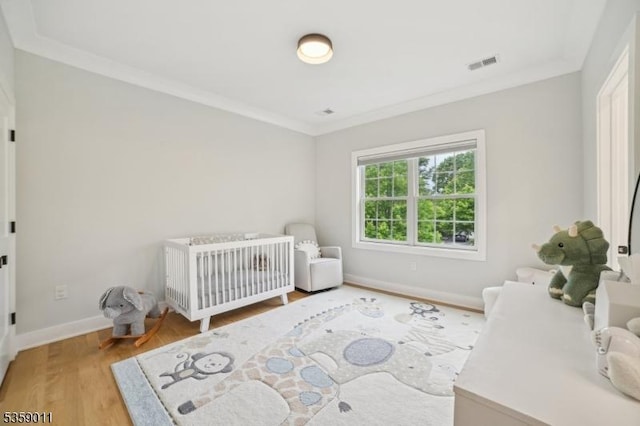 84 Elmwood Ave, Chatham Boro, NJ 07928 - bedroom featuring light wood-style floors, ornamental molding, baseboards, and a nursery area