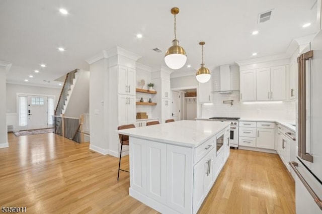 84 Elmwood Ave, Chatham Boro, NJ 07928 - kitchen with range with gas cooktop, wall chimney range hood, white cabinets, light countertops, and recessed lighting