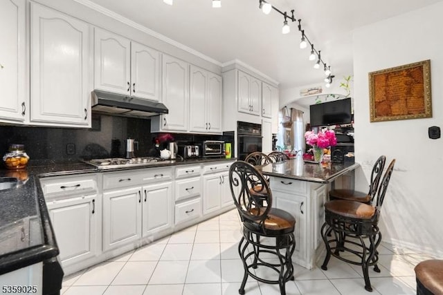 263 Morningside Ave, Cliffside Park Boro, NJ 07010 - kitchen featuring under cabinet range hood, black oven, stainless steel gas cooktop, backsplash, and light tile patterned floors