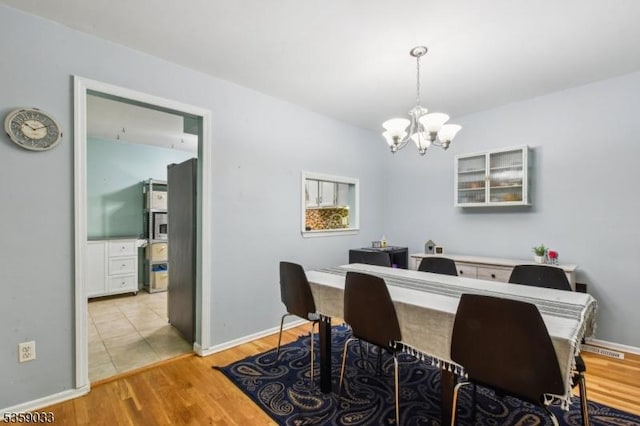 25 Manor Dr, Hillsborough Twp, NJ 08844 - dining area featuring a chandelier, light wood-type flooring, and baseboards