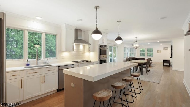 6 Balfour Ln, Scotch Plains Twp, NJ 07076 - kitchen with wall chimney exhaust hood, stainless steel appliances, a sink, a center island, and a breakfast bar