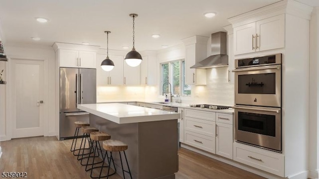6 Balfour Ln, Scotch Plains Twp, NJ 07076 - kitchen featuring appliances with stainless steel finishes, wall chimney range hood, a sink, a breakfast bar, and white cabinets