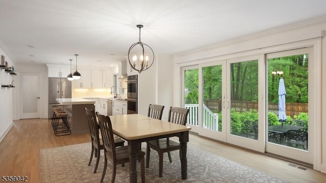 6 Balfour Ln, Scotch Plains Twp, NJ 07076 - dining room featuring light wood-style floors, a chandelier, baseboards, and crown molding