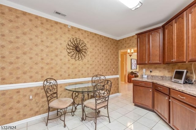 2307 Ambassador Ct Unit 2307, Franklin Twp, NJ 08873 - kitchen with wallpapered walls, light tile patterned floors, baseboards, brown cabinetry, and light stone counters