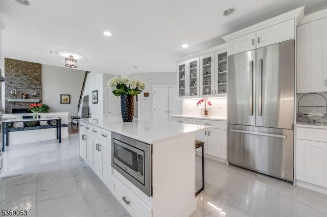 4 Greenbriar Ct, Mount Olive Twp, NJ 07836 - kitchen featuring appliances with stainless steel finishes, white cabinetry, light marble finish floors, glass insert cabinets, and a center island