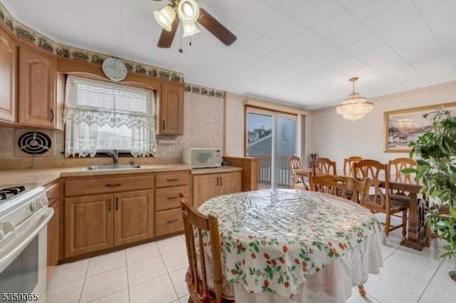 36 Bogert St, Totowa Boro, NJ 07512 - kitchen with white appliances, light countertops, healthy amount of natural light, light tile patterned floors, and wallpapered walls