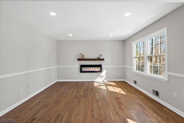 231 Sutphin Ln, Hillsborough Twp, NJ 08844 - unfurnished living room featuring wood finished floors, a glass covered fireplace, recessed lighting, and baseboards