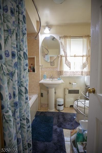 916 Sheridan Ave, Roselle Boro, NJ 07203 - full bath with radiator heating unit, shower / tub combo, a sink, and tile patterned flooring