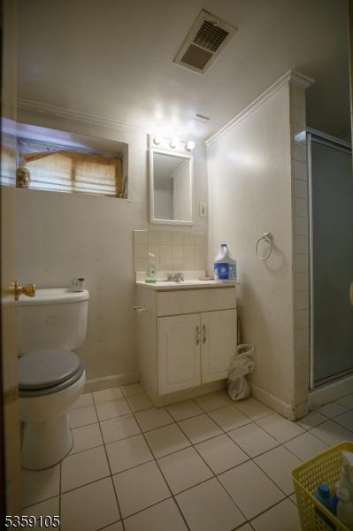 916 Sheridan Ave, Roselle Boro, NJ 07203 - full bath with tile patterned floors, a stall shower, vanity, toilet, and crown molding