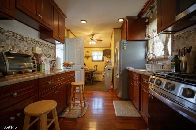 916 Sheridan Ave, Roselle Boro, NJ 07203 - kitchen featuring stainless steel appliances, ceiling fan, dark wood-style flooring, backsplash, and a breakfast bar area