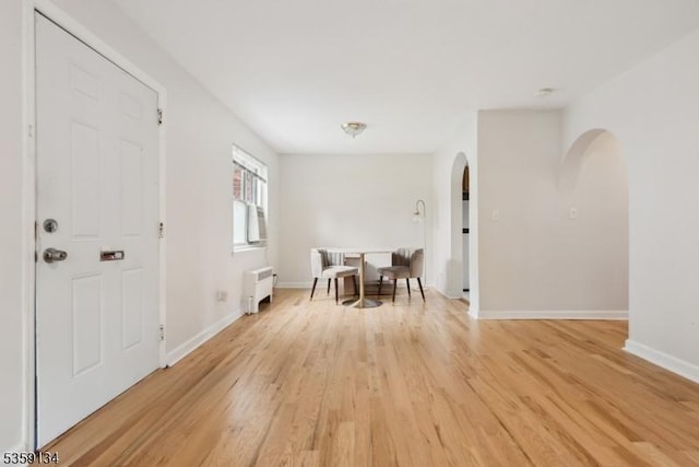 465 Maple Hill Dr Unit 51, Hackensack City, NJ 07601 - dining area featuring arched walkways, radiator, light wood finished floors, and baseboards