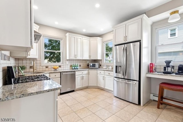 457 Academy St, South Orange Village Twp, NJ 07079 - kitchen featuring appliances with stainless steel finishes, decorative backsplash, white cabinets, a baseboard radiator, and recessed lighting