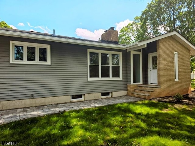 106 Hollywood Ave, Franklin Twp, NJ 08873 - rear view of house with a chimney and a lawn