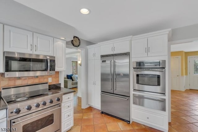 60 Dogwood Ln, Montgomery Twp, NJ 08558 - kitchen with high quality appliances, a warming drawer, white cabinets, light tile patterned flooring, and recessed lighting