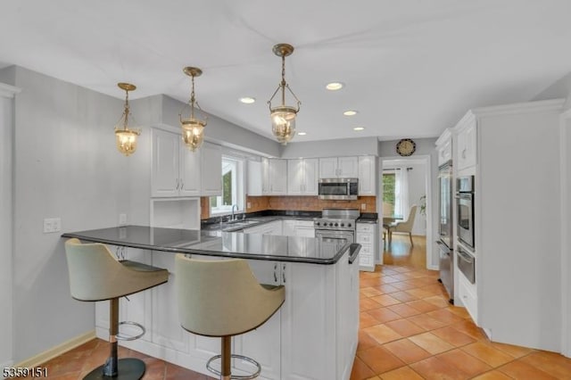 60 Dogwood Ln, Montgomery Twp, NJ 08558 - kitchen with appliances with stainless steel finishes, a peninsula, dark countertops, healthy amount of natural light, and recessed lighting