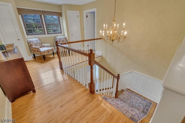 60 Dogwood Ln, Montgomery Twp, NJ 08558 - stairs featuring wood finished floors, a chandelier, a decorative wall, and wainscoting