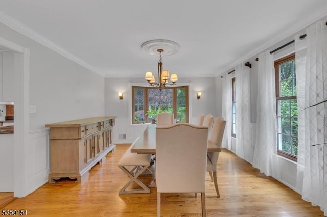 60 Dogwood Ln, Montgomery Twp, NJ 08558 - dining area featuring a chandelier, light wood-style flooring, crown molding, wainscoting, and a decorative wall
