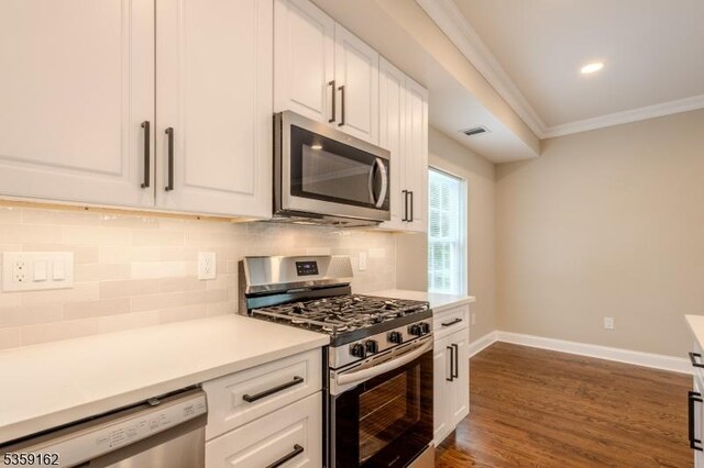 2000 Whittier St, Rahway City, NJ 07065 - kitchen with appliances with stainless steel finishes, white cabinets, ornamental molding, dark wood finished floors, and recessed lighting