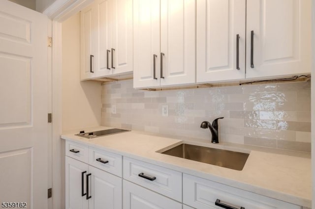 2000 Whittier St, Rahway City, NJ 07065 - kitchen with a sink, white cabinets, tasteful backsplash, and light countertops