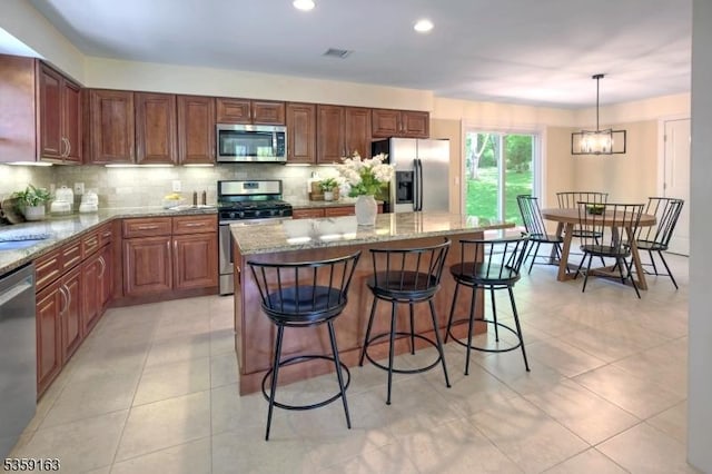 41 Lake Rd, Bernards Twp, NJ 07920 - kitchen with stainless steel appliances, tasteful backsplash, light stone countertops, a center island, and recessed lighting