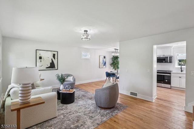 158 Old Indian Rd, West Orange Twp, NJ 07052 - living area with light wood-style flooring, plenty of natural light, baseboards, and a chandelier