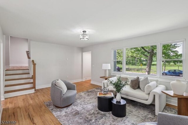 158 Old Indian Rd, West Orange Twp, NJ 07052 - living area featuring light wood finished floors, stairway, and baseboards