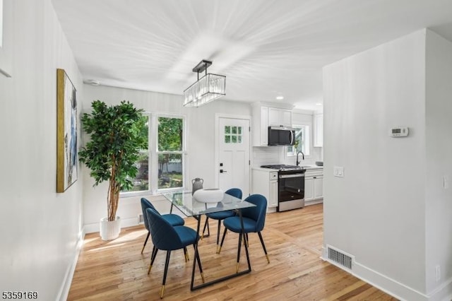 158 Old Indian Rd, West Orange Twp, NJ 07052 - dining room with baseboards, light wood-type flooring, and a chandelier
