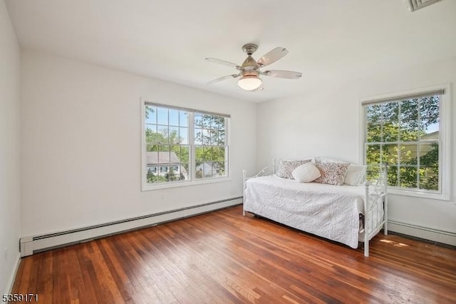 9 Baker Rd, Livingston Twp, NJ 07039 - bedroom featuring a baseboard heating unit, multiple windows, hardwood / wood-style floors, and a ceiling fan