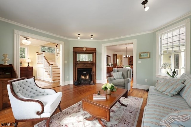 216 Kimball Ave, Westfield Town, NJ 07090 - living area with a lit fireplace, light wood-style floors, plenty of natural light, ornamental molding, and baseboards
