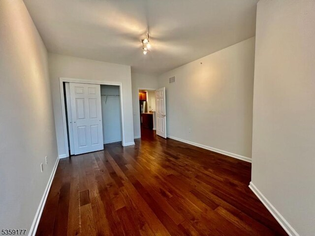 24 Ridgeview Ln Unit 24, Mount Arlington Boro, NJ 07856 - unfurnished bedroom featuring dark wood-style flooring, baseboards, and a closet