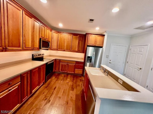 24 Ridgeview Ln Unit 24, Mount Arlington Boro, NJ 07856 - kitchen with stainless steel appliances, a sink, crown molding, hardwood / wood-style flooring, and a center island with sink