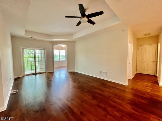 24 Ridgeview Ln Unit 24, Mount Arlington Boro, NJ 07856 - empty room featuring a raised ceiling, arched walkways, dark wood finished floors, a ceiling fan, and baseboards