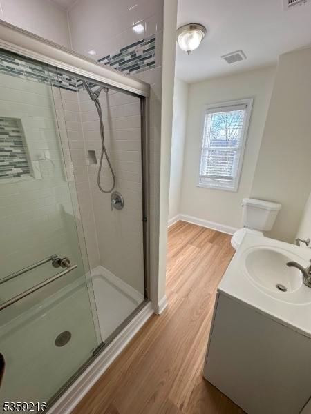 151 Sutton Ave, Totowa Boro, NJ 07512 - full bathroom featuring a stall shower, wood finished floors, vanity, and baseboards
