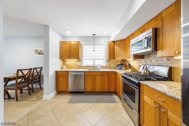 29 E Price St Unit 2, Linden City, NJ 07036 - kitchen featuring stainless steel appliances, a sink, backsplash, brown cabinetry, and light stone counters