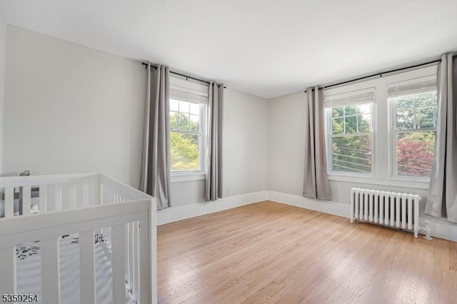 114 Hoagland Ave, Rockaway Boro, NJ 07866 - unfurnished bedroom with radiator heating unit, multiple windows, and wood finished floors