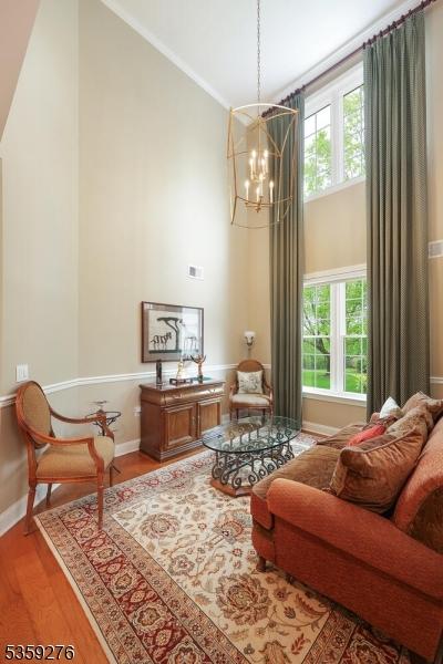37 Hancock Pl, Franklin Twp, NJ 08873 - living area featuring healthy amount of natural light, wood finished floors, a chandelier, baseboards, and a high ceiling
